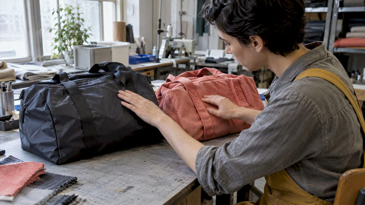 Hands comparing nylon and polyester bag fabrics