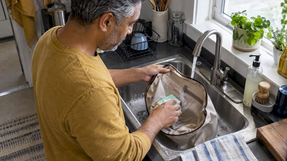 Removable bag lining being sponged at a sink