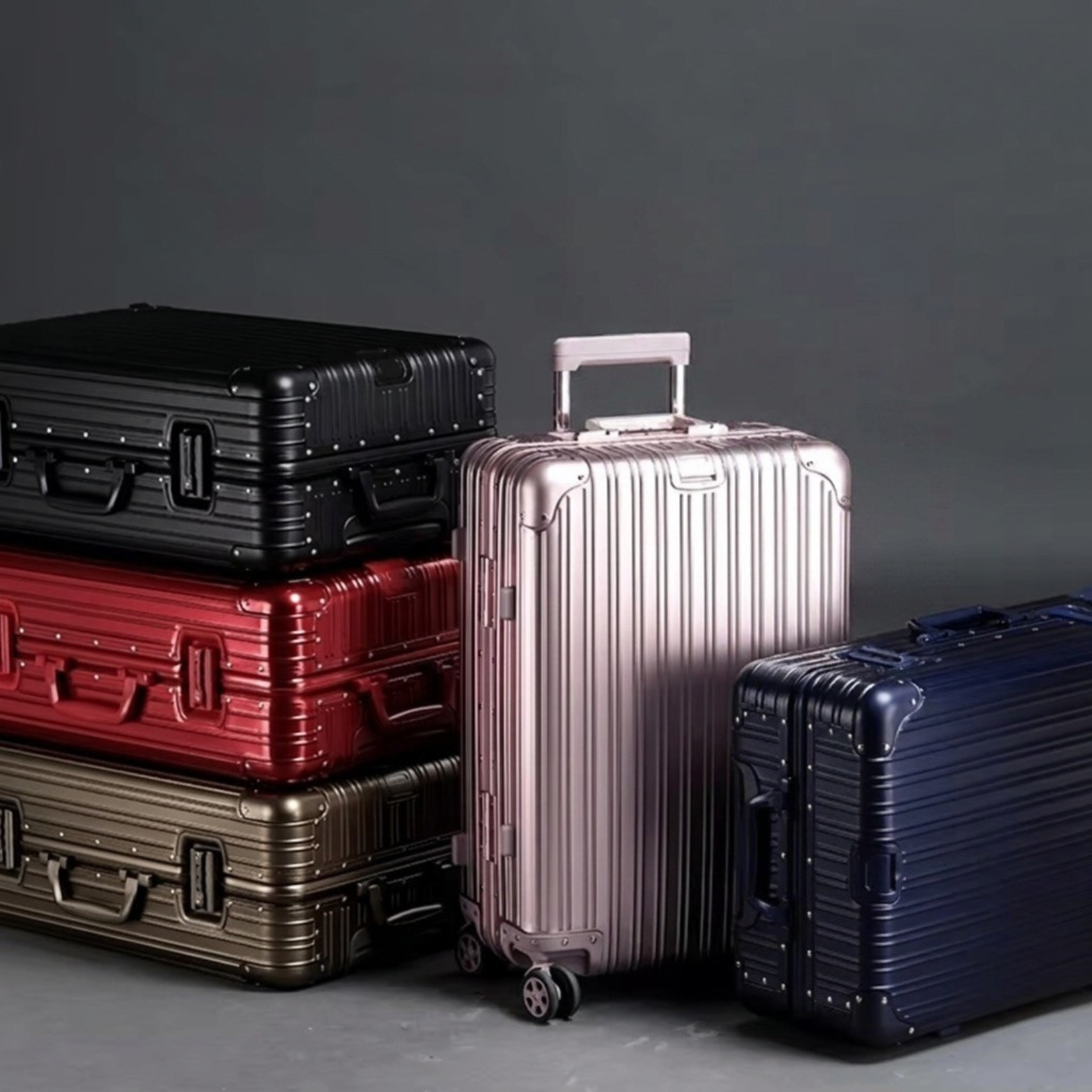 Lineup of SPRITZ™ Bourdain Suitcases in black, red, bronze, rose gold, and navy aluminum hard-shell finishes